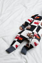 Children's onesie with car and checkered pattern on a white surface