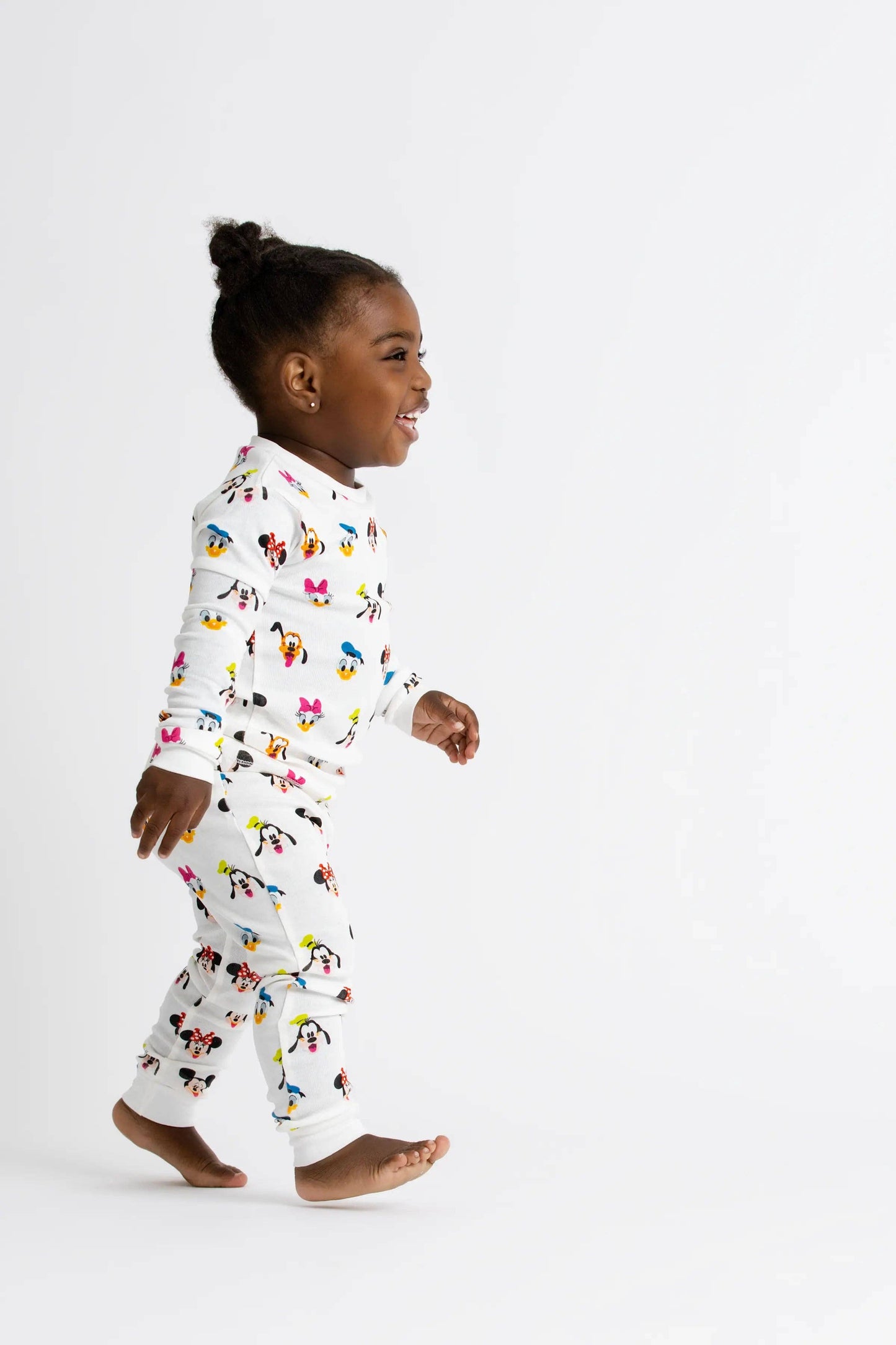 Child wearing a colorful pajama set with a white background